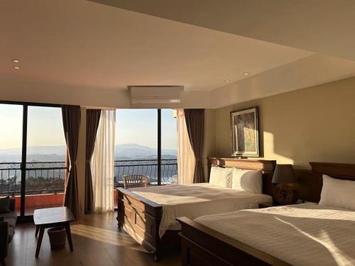 a hotel room with two beds and a large window at Sunshine B&B in Jiufen