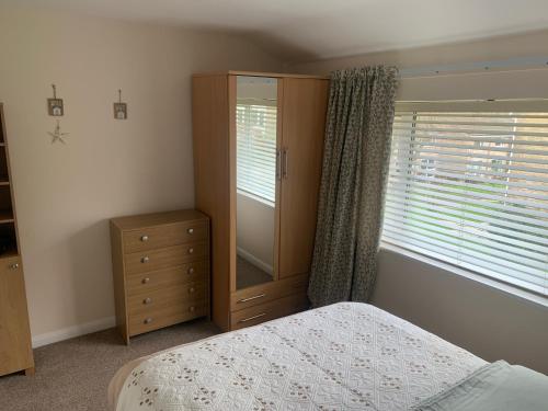 a bedroom with a bed and a dresser and a window at Seabrook Lodge in Newquay