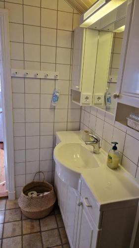 a bathroom with a sink and a mirror and a basket at Lilla huset in Klädesholmen