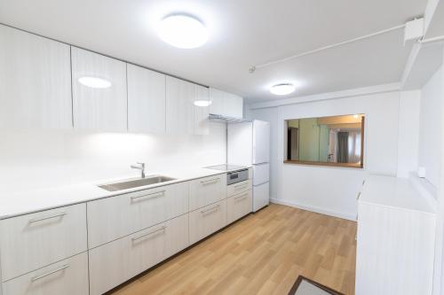 a kitchen with white cabinets and a sink at Shirahama White Beach House - Self Check-In Only in Shirahama
