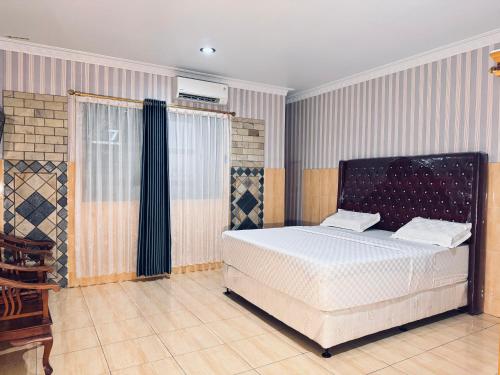 a bedroom with a white bed and a window at Hotel Grand Bandara in Medan