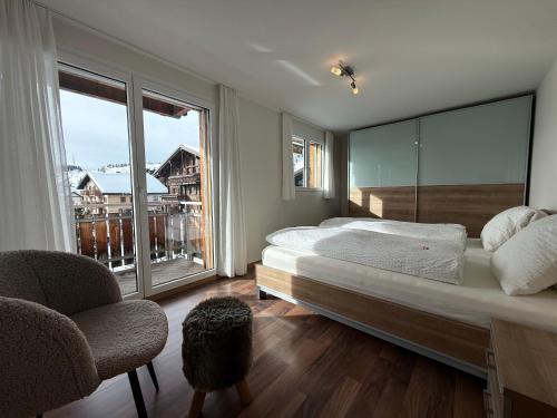 a bedroom with a large bed and a large window at Bergquelle 2. OG in Bettmeralp