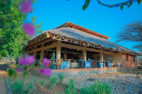 un edificio con un tetto e delle persone sedute sopra di Paradise Lodge Turmi a Turmi