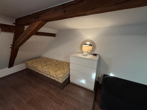 Un dormitorio con una cama y una lámpara sobre una cómoda. en Underhillhouse, en Liběšice