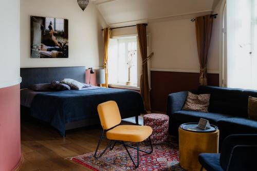 a bedroom with a bed and a couch at Herberg d'n brouwer in Zeeland