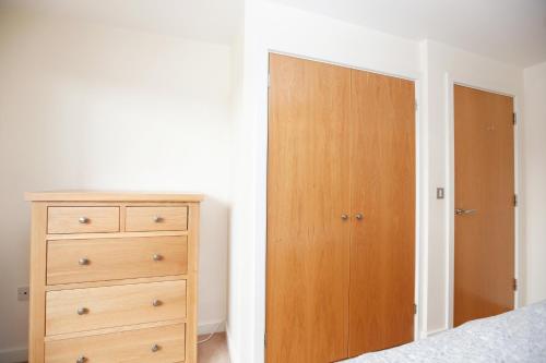 una camera da letto con un mobile in legno e una cassettiera di Coventry Home a Coventry