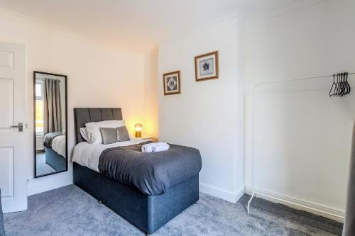 a bedroom with a bed and a mirror at Barnwell by Holmesdale Homes in Kettering
