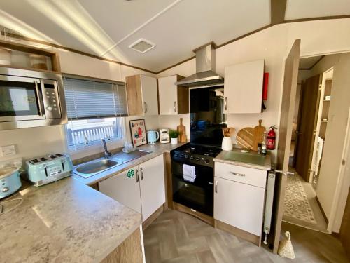 a small kitchen with a sink and a stove at The Waterfront in South Cerney