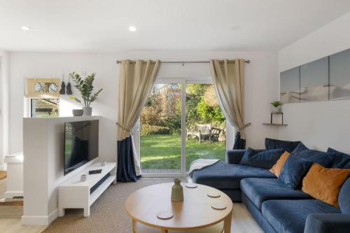 a living room with a blue couch and a tv at Beautiful Apartment with Parking Central Exeter in Dean