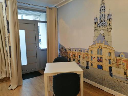 a room with a table and a building on the wall at Le Coeur du Beffroi in Douai