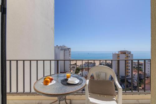 a table on a balcony with a view of the ocean at Cruzeiro - Silhueta Citadina in Portimão