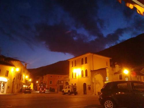 a street at night with cars parked in front of buildings at Al Cavallino in Follina