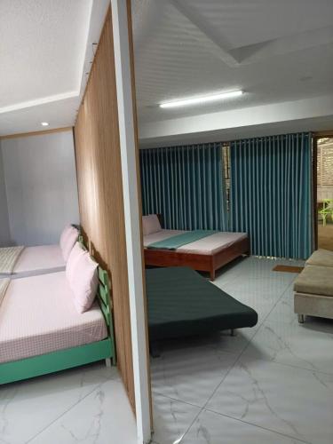 a room with two beds and a couch at NHÀ KHÁCH KEN in Cà Mau