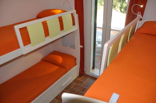 two bunk beds in a room with a window at Tenuta le marze in Castiglione della Pescaia