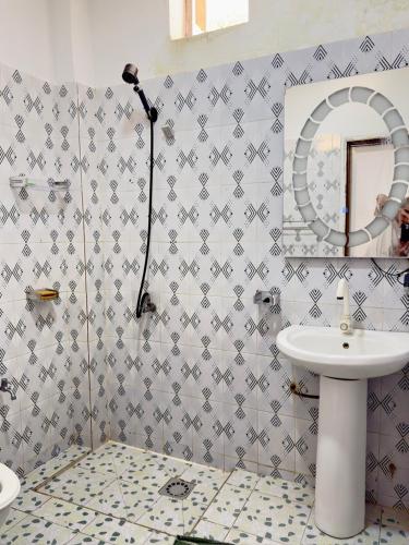a bathroom with a sink and a mirror at Residence MiMi Alouar Ziguinchor in Tilel