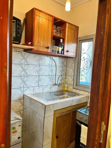 eine kleine Küche mit Spüle und Fenster in der Unterkunft Nouji in Douala