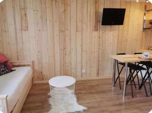 a room with a couch and a table and a tv at Jonquille 5 personnes in Chamonix