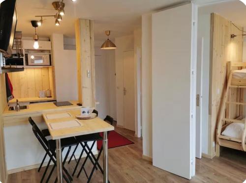 a small kitchen with a table and a kitchen with a bed at Jonquille 5 personnes in Chamonix