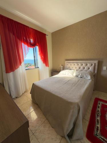 a bedroom with a large bed and a window at Casa Brisa do Mar in Governador Celso Ramos
