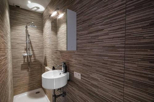 a bathroom with a sink and a glass shower at Maison Bonheur in Bruges
