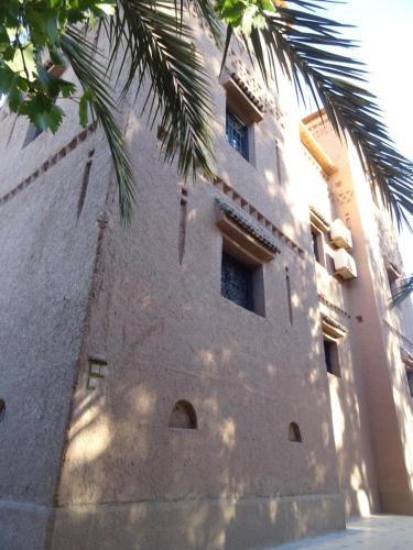 a building with a palm tree in front of it at PALM'SKOURA in Skoura