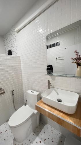 a white bathroom with a toilet and a sink at สังข์เงินรีสอร์ท2 in Nakhon Sawan