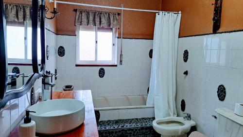 a bathroom with a tub and a toilet and a sink at Casa da Maíssa in Ponta Delgada
