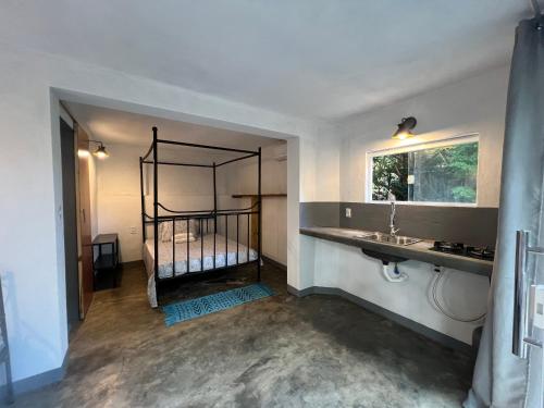 a bedroom with a bed and a sink and a mirror at Maison das Artes morere in Cairu