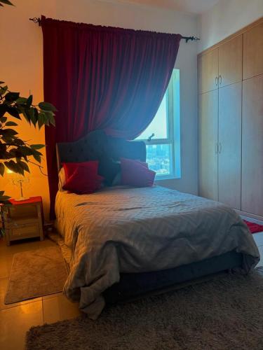a bedroom with a bed with a curtain and a window at Royal rooms Ajman in Ajman