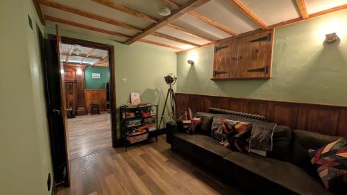 a living room with a couch in a room with wooden floors at Bradford Canal Pump House, Shipley near Saltaire in Shipley