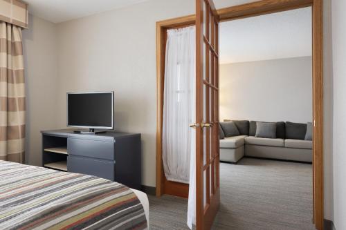 a room with a bed and a tv and a couch at Country Inn & Suites by Radisson, Minneapolis-Shakopee in Shakopee