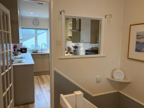 a kitchen with a counter and a sink and a window at Lansdowne - Charmouth Sea Retreat in Bridport