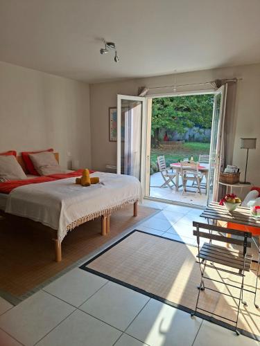 a bedroom with a bed and a patio with a table at Studio Lumineux avec jardin & piscine à Vaison la Romaine in Vaison-la-Romaine