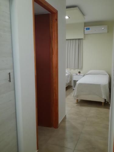 a room with a bed and a door leading to a bedroom at Hotel Mirador de las Sierras in Villa Carlos Paz