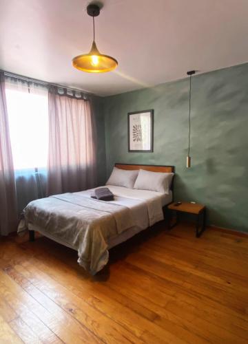 a bedroom with a bed and a large window at Compact Studio Apartment Casa Icacos Apt 5 in Mexico City