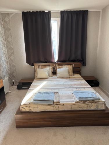 a bedroom with a large bed with a large window at Forum Apartment in Stara Zagora