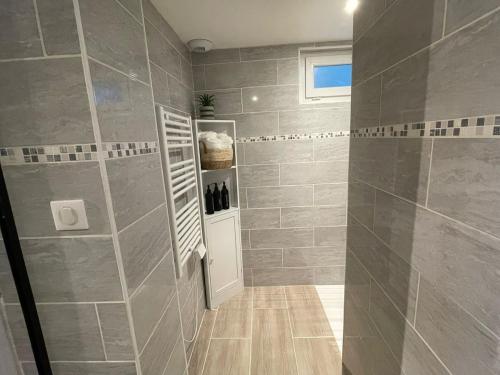 a bathroom with a shower with gray tiles at Studio - Free Parking - Netflix - Wi-Fi in Brive-la-Gaillarde