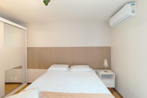a bedroom with a large white bed in it at Espaçoso e Confortável Próximo da UEM - EL08 in Maringá