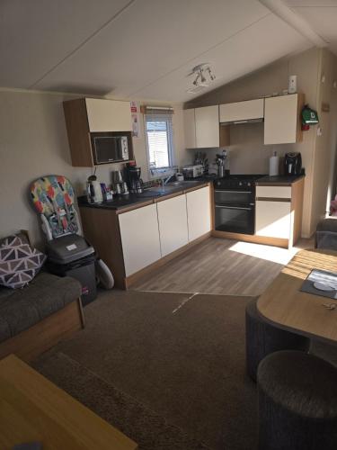 a kitchen and living room with a couch and a table at Trecco bay birch in Newton