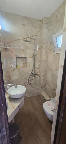 a bathroom with two sinks and a toilet at Studios Kofos Limin in Porto Koufo