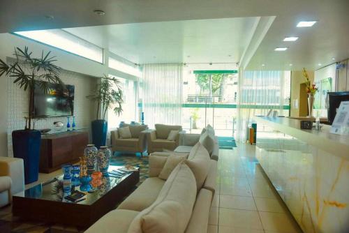 a living room with a white couch and a table at Hotel Village in Garanhuns