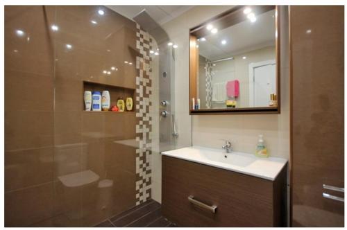 un bagno con lavandino e doccia con specchio di Tulipa View Apartament a Funchal
