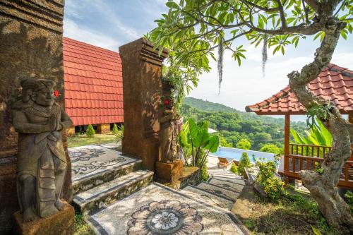 a building with statues on the side of it at Kubu Diar by Manara in Seraya