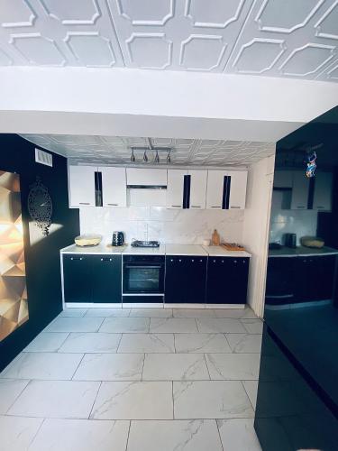 a kitchen with blue cabinets and a white tile floor at Dom Nad Brzegiem Jeziora in Ryn