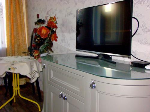 una TV seduta sopra un comò di Elegant Apartment a Riga