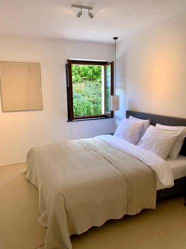 a bedroom with a large bed with a window at Residenza Marrone in Montefalco