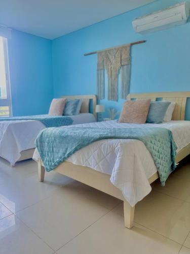 a bedroom with two beds in a blue room at 5El apartamento que todos quieren in Santa Marta