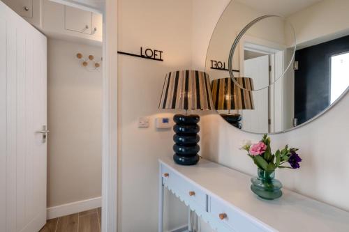 a room with a table with a mirror and a vase with flowers at 2 Bed in Holt oc-l31797 in Holt