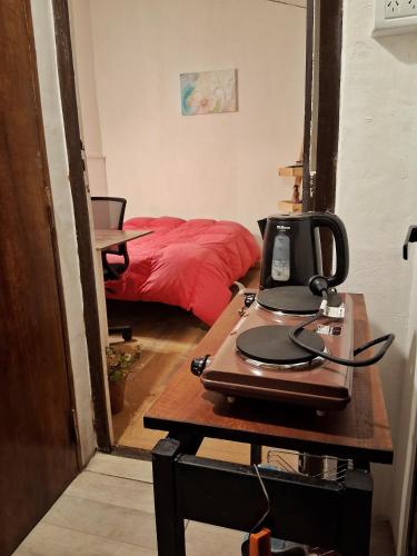 a room with a bed and a desk with a sewing machine at Castelli b&b in Mar del Plata