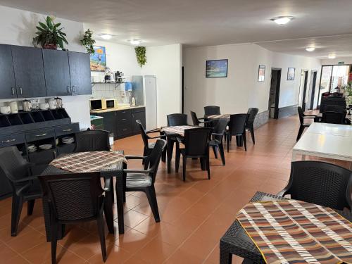 a restaurant with tables and chairs and a kitchen at Beach Hostel Balatonboglár in Balatonboglár
